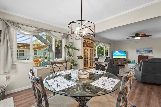 dining area with crown molding, baseboards, ceiling fan with notable chandelier, and wood finished floors