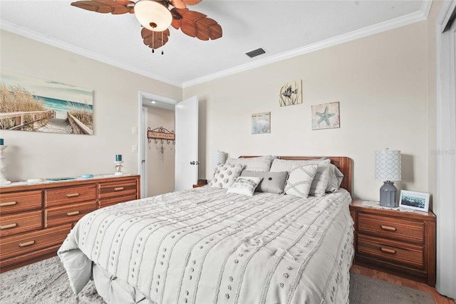 bedroom featuring crown molding, a ceiling fan, visible vents, and light wood finished floors