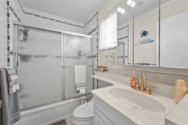 full bath with shower / bath combination with glass door, toilet, decorative backsplash, and vanity