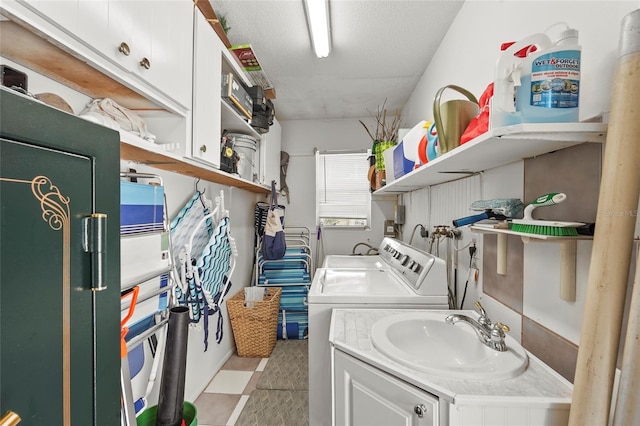 washroom with a sink, washing machine and dryer, and a textured ceiling