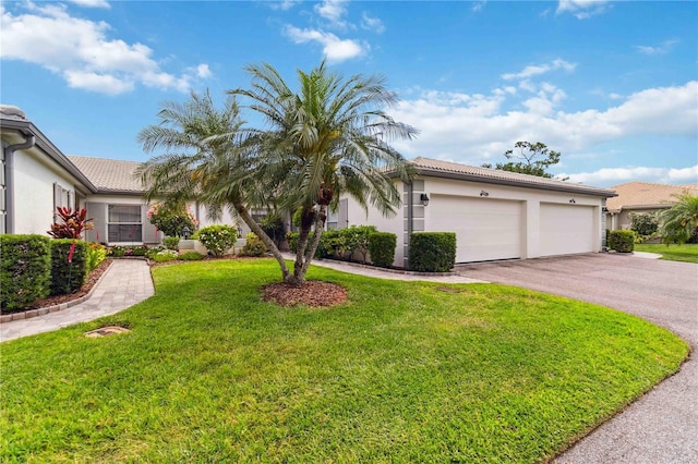 view of front of house featuring an attached garage, a tile roof, aphalt driveway, stucco siding, and a front yard