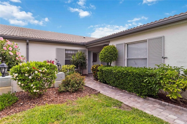 view of front of property featuring stucco siding and a tiled roof