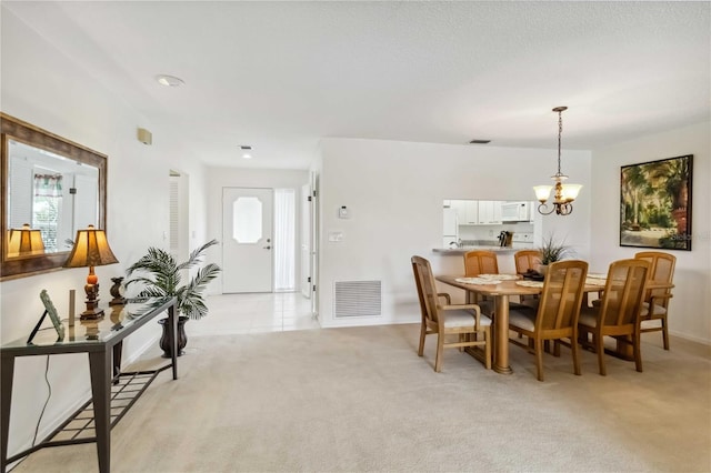 dining space featuring a chandelier, light colored carpet, a wealth of natural light, and visible vents