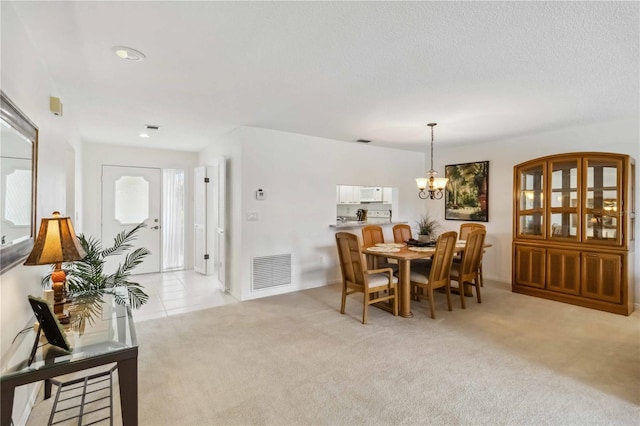 dining room featuring visible vents, a chandelier, and light colored carpet