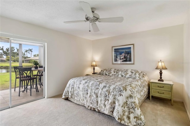 bedroom with a ceiling fan, access to exterior, baseboards, a water view, and carpet