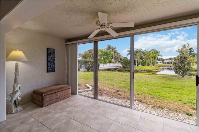 sunroom featuring a water view and ceiling fan