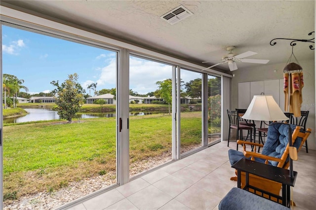 sunroom / solarium featuring a water view, plenty of natural light, and visible vents