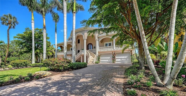 975 Whitakers Ln, Sarasota, FL 34236 - mediterranean / spanish-style home featuring stairway, stucco siding, a porch, decorative driveway, and an attached garage