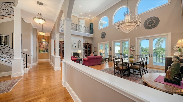 975 Whitakers Ln, Sarasota, FL 34236 - living area featuring ornamental molding, plenty of natural light, light wood-type flooring, a high ceiling, and baseboards