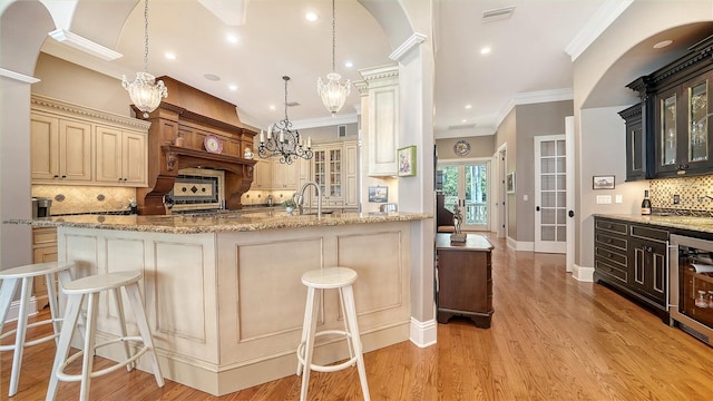 975 Whitakers Ln, Sarasota, FL 34236 - kitchen with crown molding, decorative backsplash, a chandelier, glass insert cabinets, and beverage cooler