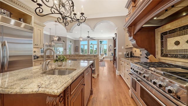 975 Whitakers Ln, Sarasota, FL 34236 - kitchen with high end appliances, a sink, a ceiling fan, a chandelier, and ornamental molding