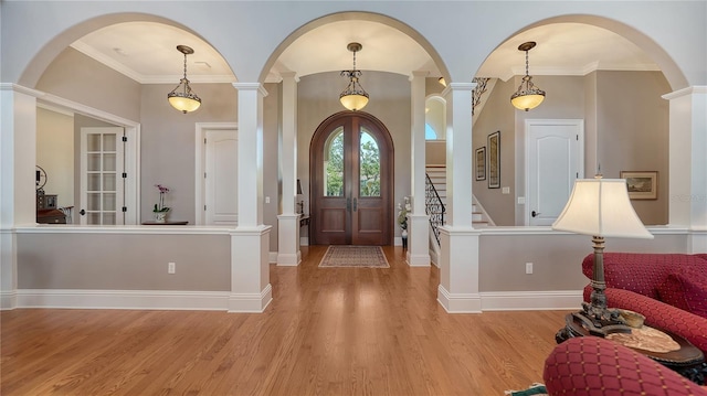 975 Whitakers Ln, Sarasota, FL 34236 - entryway featuring light wood-style flooring, ornamental molding, baseboards, arched walkways, and decorative columns