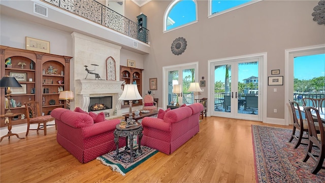 975 Whitakers Ln, Sarasota, FL 34236 - living room with wood finished floors, a high ceiling, a lit fireplace, and baseboards