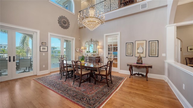 975 Whitakers Ln, Sarasota, FL 34236 - dining space with french doors, a high ceiling, light wood-style floors, baseboards, and a chandelier