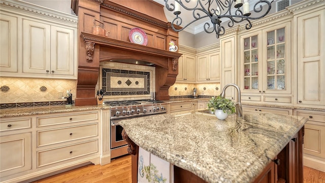 975 Whitakers Ln, Sarasota, FL 34236 - kitchen featuring cream cabinetry, high end stainless steel range oven, a sink, and a chandelier