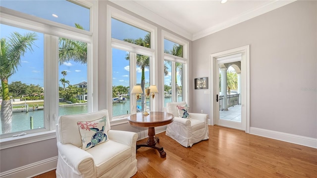 975 Whitakers Ln, Sarasota, FL 34236 - sunroom / solarium featuring a water view, wood finished floors, baseboards, and crown molding