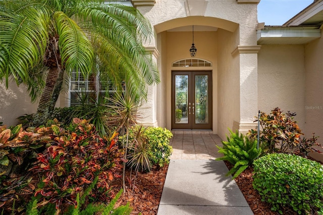 property entrance with stucco siding and french doors