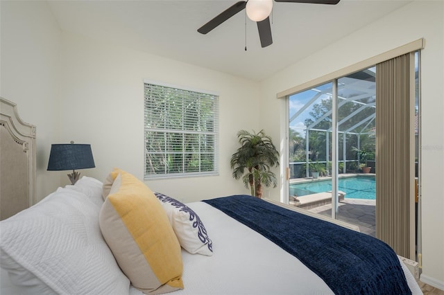 bedroom featuring baseboards, a ceiling fan, a sunroom, and access to exterior