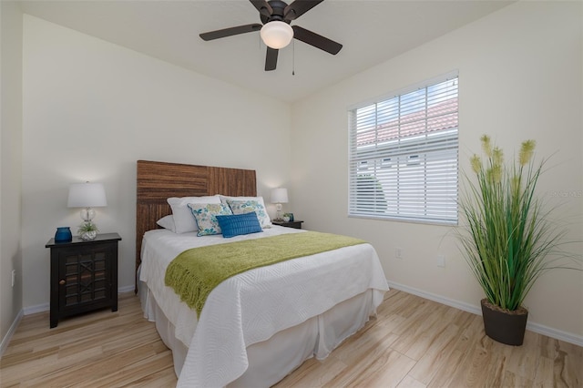 bedroom with baseboards, ceiling fan, and wood finished floors