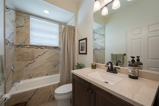 bathroom with vanity, tiled shower / bath combo, and toilet