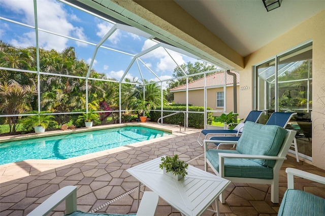 outdoor pool with glass enclosure and a patio area
