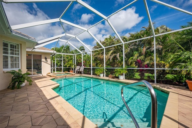 view of swimming pool with glass enclosure, a pool with connected hot tub, and a patio area