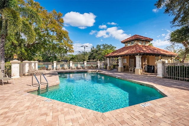 community pool featuring fence and a patio area