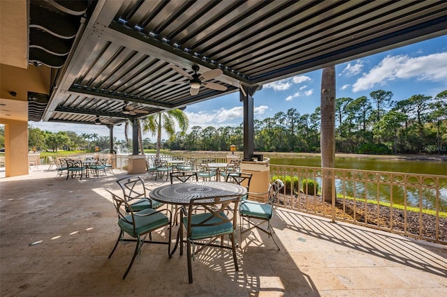 view of patio with a water view, ceiling fan, and outdoor dining space