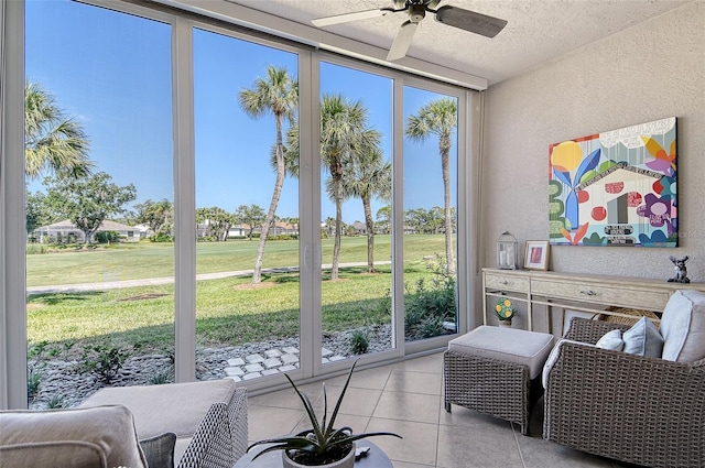 sunroom with a ceiling fan and golf course view