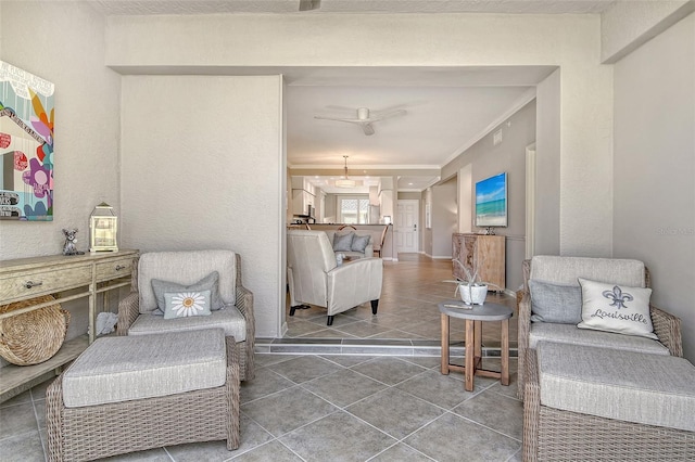 sitting room featuring crown molding, a ceiling fan, and tile patterned flooring