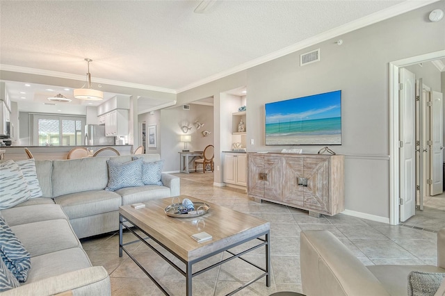 living area with a textured ceiling, visible vents, crown molding, light tile patterned floors, and baseboards