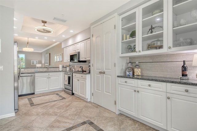 kitchen with ornamental molding, decorative backsplash, glass insert cabinets, white cabinetry, and stainless steel appliances