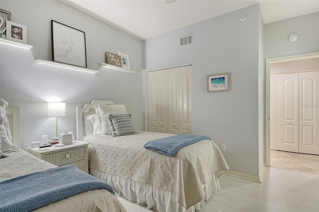 bedroom with baseboards, visible vents, and a closet