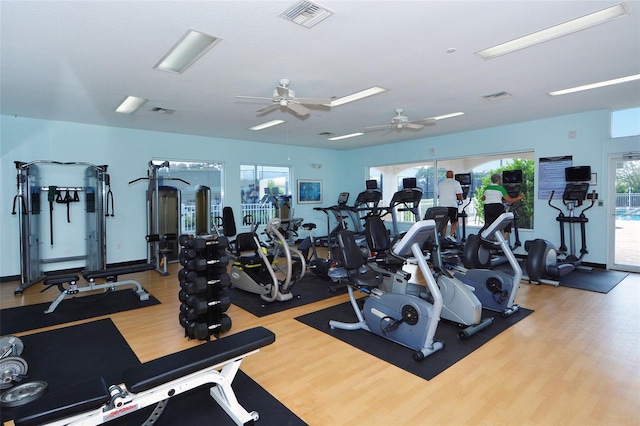 workout area with a ceiling fan, visible vents, and wood finished floors