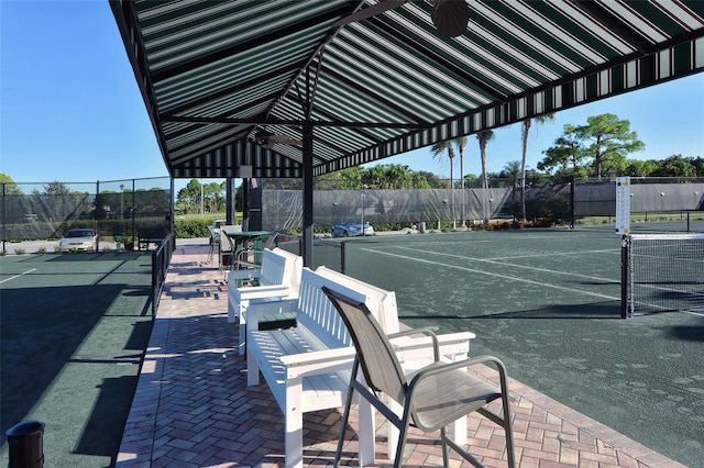 view of community with fence and a tennis court