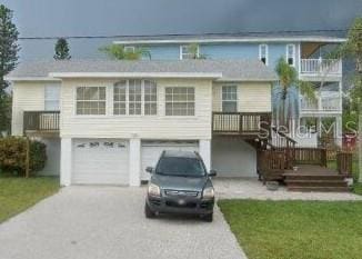beach home with driveway and an attached garage