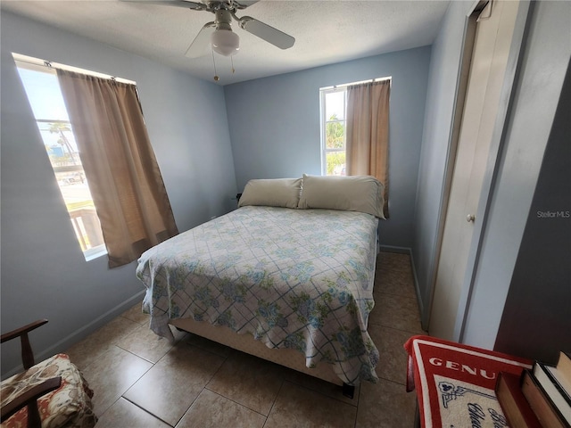 tiled bedroom with baseboards and ceiling fan