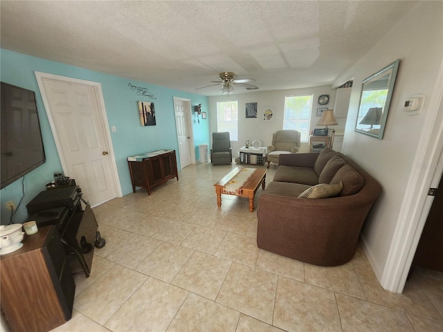 living room featuring ceiling fan, a textured ceiling, and light tile patterned floors