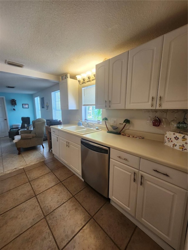 kitchen with dishwasher, a sink, white cabinetry, a textured ceiling, and open floor plan