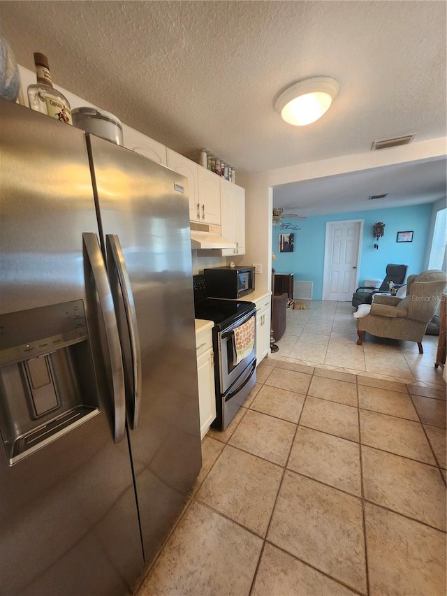 kitchen with stainless steel appliances, white cabinets, light tile patterned floors, under cabinet range hood, and a textured ceiling