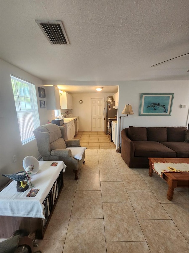 living room with light tile patterned floors and a textured ceiling