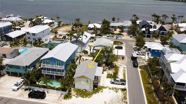 aerial view of residential area with a nearby body of water and a pool