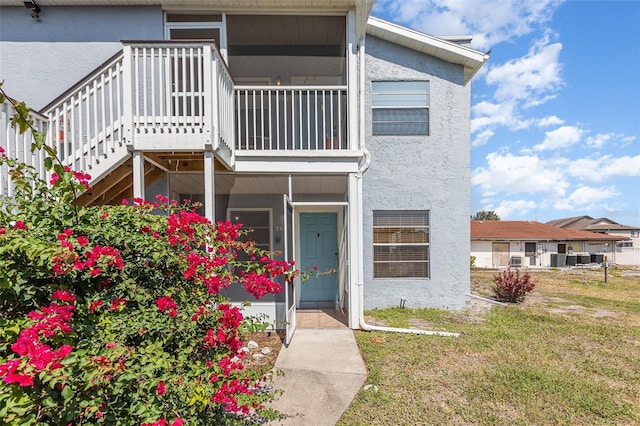 3781 59th Ave W Unit 3781, Bradenton, FL 34210 - view of front of house with stucco siding, a front yard, a sunroom, and stairs