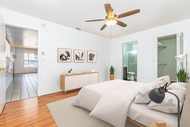 3781 59th Ave W Unit 3781, Bradenton, FL 34210 - bedroom featuring light wood-type flooring, ensuite bath, ceiling fan, and a walk in closet