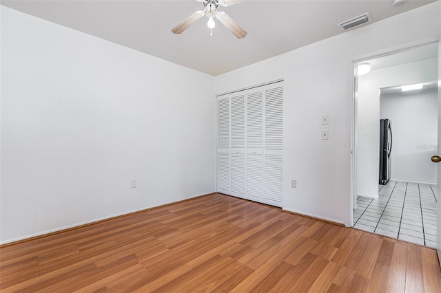 3781 59th Ave W Unit 3781, Bradenton, FL 34210 - unfurnished bedroom featuring freestanding refrigerator, light wood-style floors, a closet, and ceiling fan