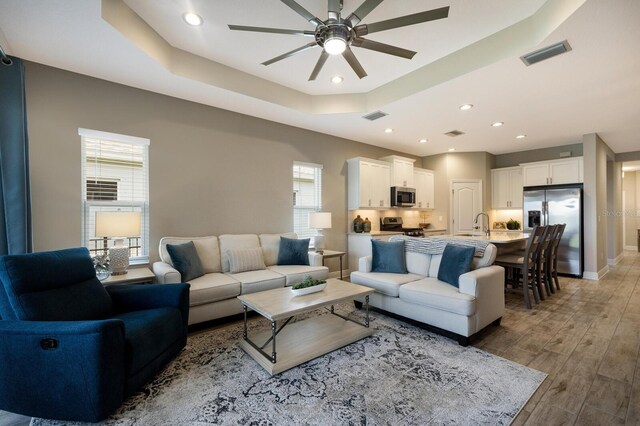 4815 Deep Creek Ter, Parrish, FL 34219 - living room with healthy amount of natural light, a tray ceiling, ceiling fan, light wood finished floors, and recessed lighting