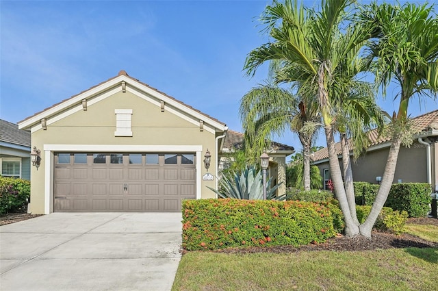 view of front of home with stucco siding, driveway, and an attached garage