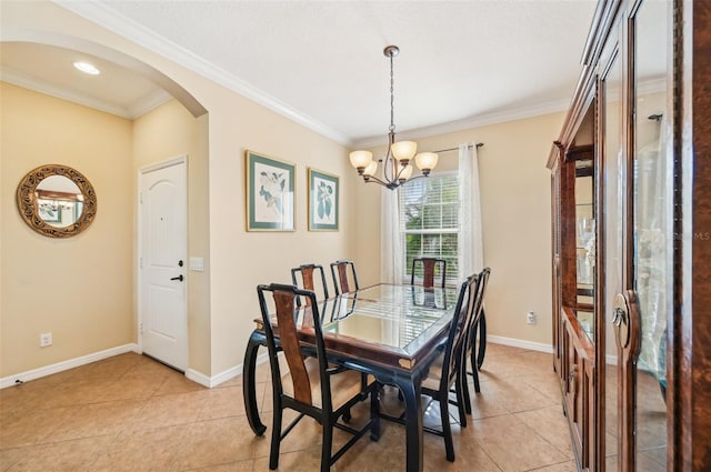 dining area featuring arched walkways, light tile patterned floors, a chandelier, ornamental molding, and baseboards