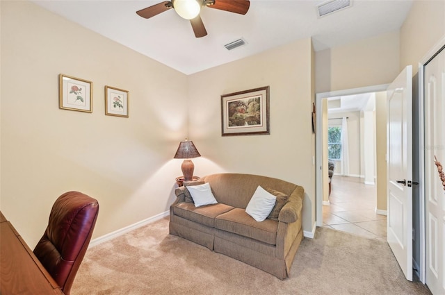 home office featuring light carpet, ceiling fan, baseboards, and light tile patterned flooring