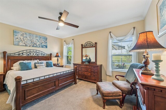 bedroom featuring light carpet, crown molding, and a ceiling fan
